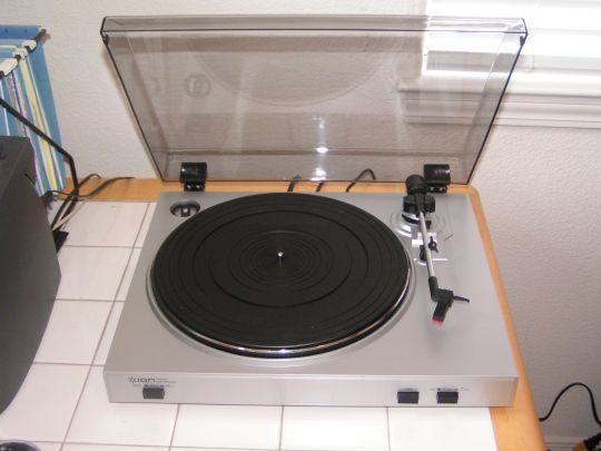 Overhead photo of the Ion Audio TTUSB05. The dustcover is raised and the platter is empty. The tone arm is in resting position.